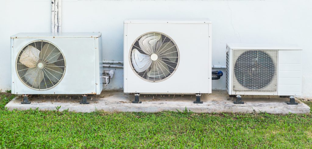 Three old air conditioner beside home