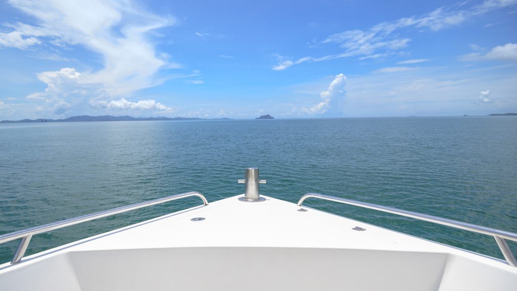 A view of front luxury speedboat with a beautiful ocean and mountain in background