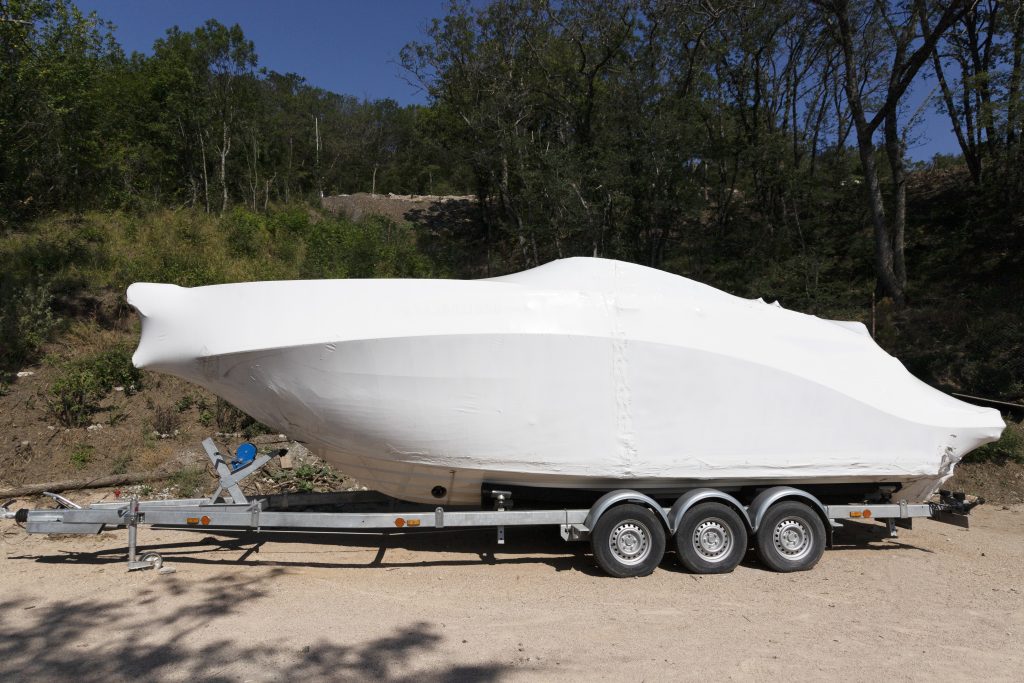 Transportation of a new pleasure boat, yacht on a car trailer, semitrailer. High quality photo